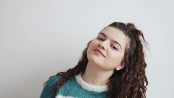 Mujer seria riendo en cámara lenta. Chica sonriente mirando en la cámara en el fondo ingenioso. Cara de mujer feliz riendo en el estudio. Modelo de moda cara sonriente . — Vídeo de stock