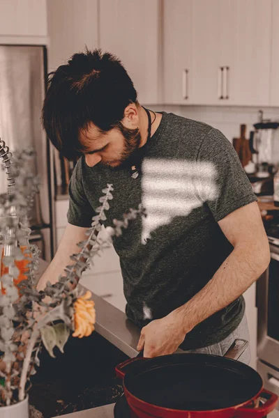 Husband washes dishes after dinner. Scraper for dirty dishes. Kitchen sink. Dish soap dish sponge. Home work. Stay home. Lockdown during the quarantine. Lifestyle kitchen. Dishwasher in the kitchen.