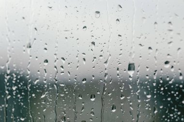 Pencereye yağmur damlaları düşer. Nisan, Mayıs 'ta bahar fırtınası. Yaz gök gürültüsü. Yazın hüzün, melankolik hüzün. Makro yağmur damlaları. Bokeh etkisi. Dağınıklık ve rahatlama. Hava bulutlu. Sonbahar günü.