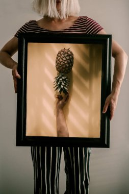 Minimalist sarı fon, ananas meyvesi. Parlak renkli içerik. Kağıt arkaplan. Tropik egzotik meyve. Turuncu renk, sarı. Renk belirdi. Sert ışık, yumuşak gölgeler. Doğrudan güneş ışığı. Gölgeler