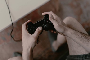 Hippi adam kanepede video oyunu oynuyor. Dinlenme zamanı. Eğlenceli bir hafta sonu. Bir video oyununa odaklanmış. Oyunu kazanmak, kumar oynamak. Çoklu oyuncu oyunu. Çevrimiçi oyun. Yayınlanan video oyunu. Futbol, yarış