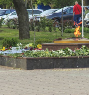 Ebedi Ateş, bir yıldız ve çiçekli bir anıt Meçhul Asker 'in Mezarı üzerinde bir sokak manzarası olan Moldova Kahul 09.05.2019' un zemininde taze çiçeklerle çevrili..  
