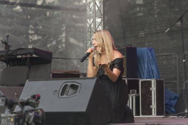 Moldova Cahul 06.16. 2019 Uluslararası Müzik Festivali Dostların Yüzleri. Şarkıcı dizlerinin üstünde şarkı söyler. 
