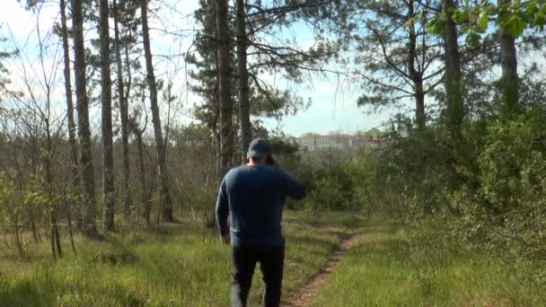 Man Talking Cell Phone Goes Forest Path — Stock Video