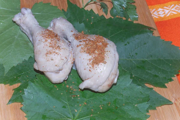 两只半熟的鸡腿 用葡萄叶磨碎调料 — 图库照片