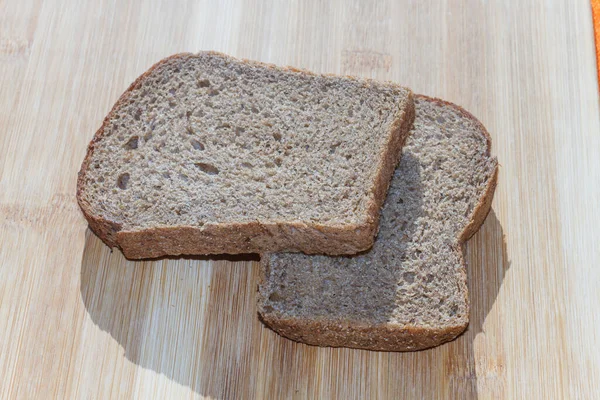 木の板の上に2切れの茶色のパンが — ストック写真