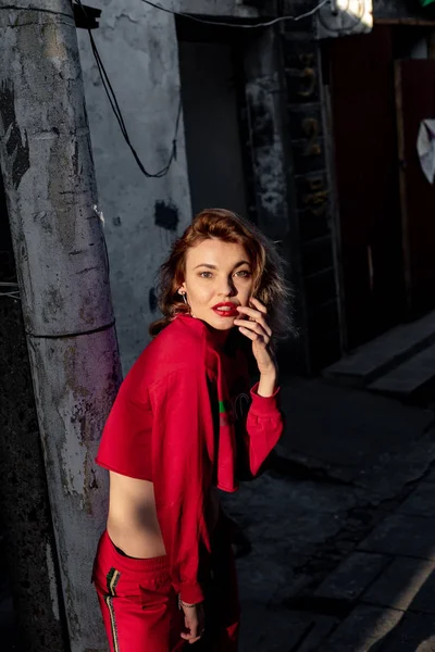 Ένα Κορίτσι Ένα Κόκκινο Σπορ Κοστούμι Έναν Γκρι Δρόμο — Φωτογραφία Αρχείου