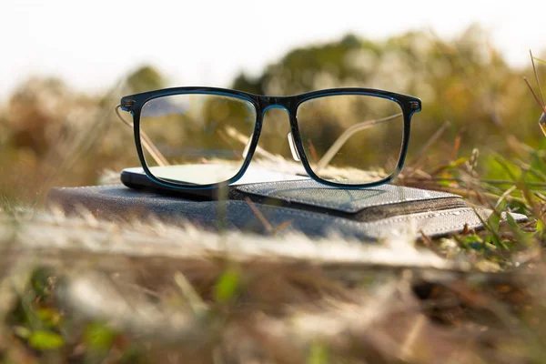 Szemüveg Egy Füzeten Fűben — Stock Fotó