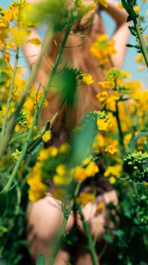 Sarı çiçekli iç çamaşırlarıyla poz veren sarışın bir kadın.