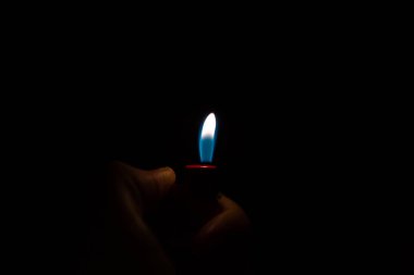 Koyu arkaplanda el ele tutuşan çakmağı kapat 