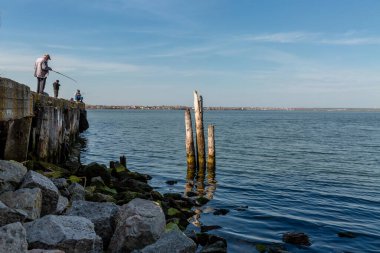 Balıkçılar gündüz vakti köprüde balık tutuyor. 
