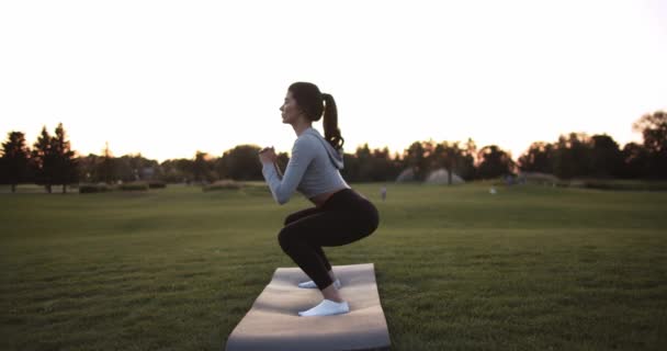 Junge Frau Macht Kniebeugen Bei Sonnenuntergang Park Zeitlupe Sportliches Mädchentraining — Stockvideo