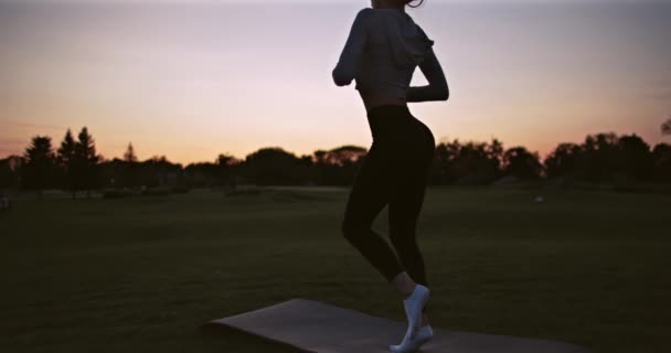 Der Athlet Wärmt Sich Bei Sonnenuntergang Auf Der Straße Auf — Stockvideo