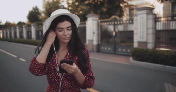 Молодая Девушка Слушает Музыку Наушниках Держа Телефон Замедленной Съемке Красивая — стоковое видео