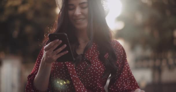 Gelukkig Meisje Lacht Met Een Telefoon Haar Handen Bij Zonsondergang — Stockvideo