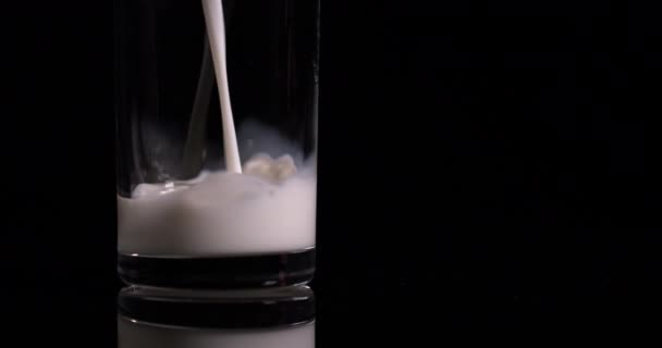 éclaboussures de lait verser dans un verre sur un fond noir au ralenti 