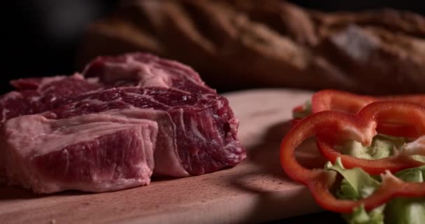 Syrový Steak Zeleninou Leží Dřevěné Desce Černém Pozadí Zpomaleném Filmu — Stock video