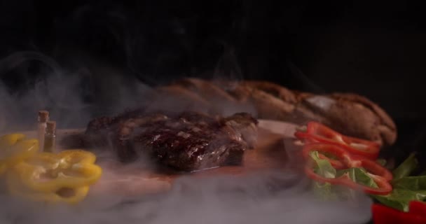 연기에 스테이크는 배경에 향신료와 야채와 느리게 움직이고 있습니다 고기를 — 비디오
