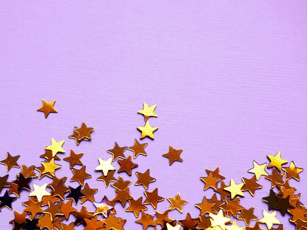 Złote gwiazdy błyszczą na fioletowym tle — Zdjęcie stockowe