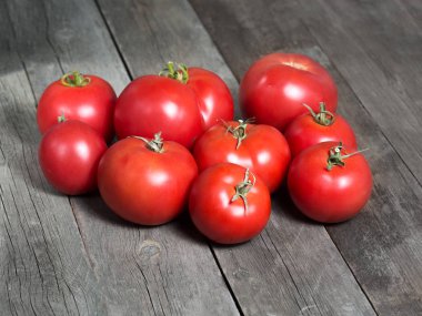 Köhne ahşap masada olgun kırmızı domatesler..