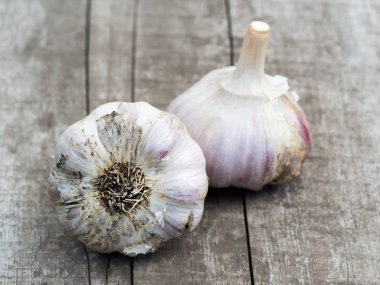 Arkadaki ahşap masada organik sarımsak soğanları..