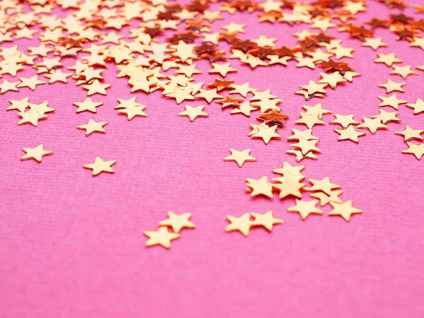 Estrelas douradas brilham sobre fundo rosa — Fotografia de Stock