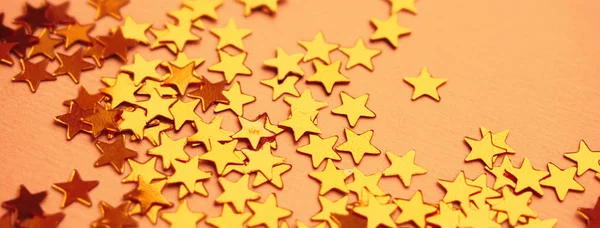 Arany csillagok csillognak narancssárga papír háttér — Stock Fotó