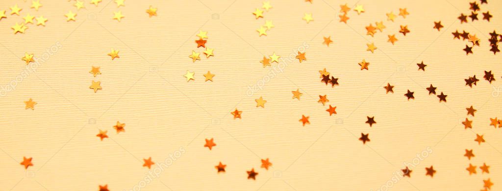 Golden stars glitter on yellow paper background Stock Photo