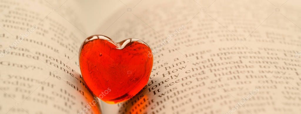 Red transparent glass heart lay in a book Royalty Free Stock Images