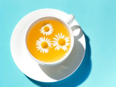 Fincanda taze papatya çiçekleri olan bitki çayı.