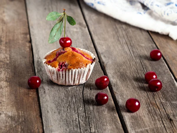 Muffins de cereja recém-assados closeup em uma mesa rústica — Fotografia de Stock