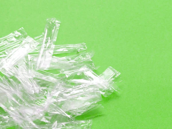 緑の背景に透明なプラスチック包装廃棄物の山. — ストック写真
