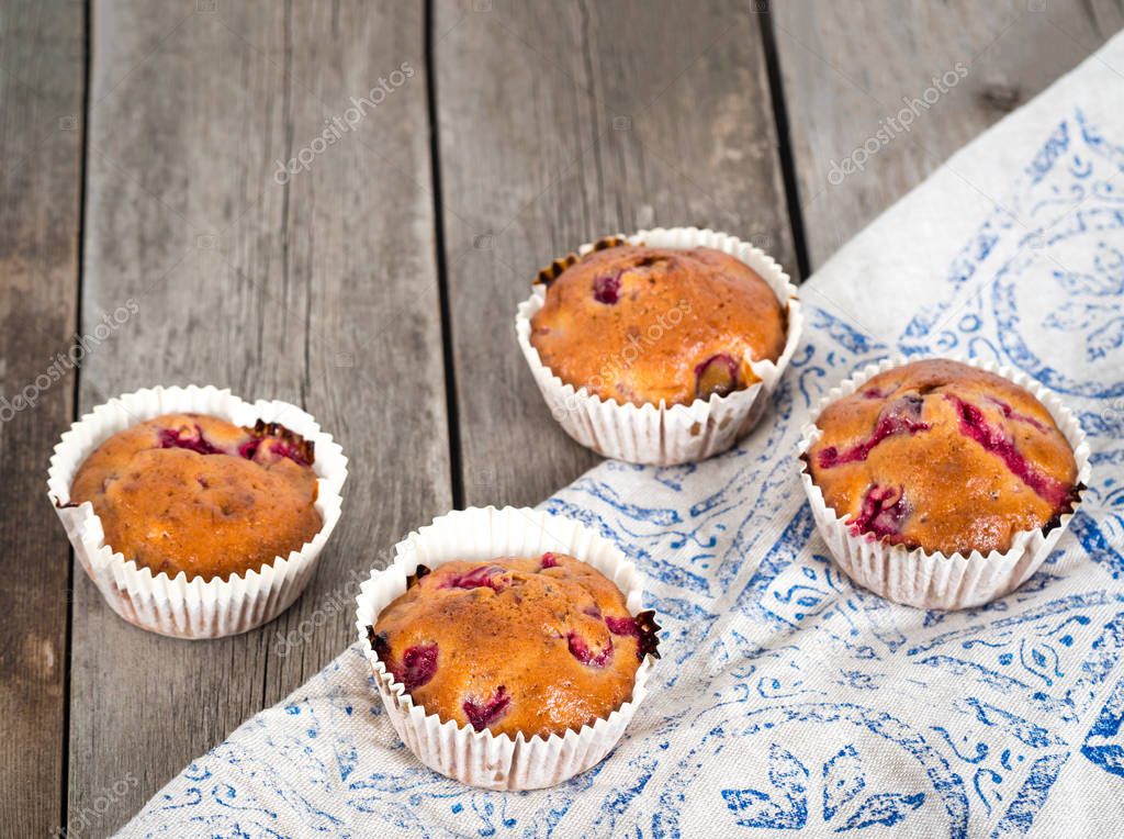 Freshly baked cherry muffins closeup on a rustic table