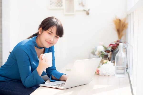 Mooie jonge freelance Aziatische vrouw glimlachend werken en op schoot — Stockfoto