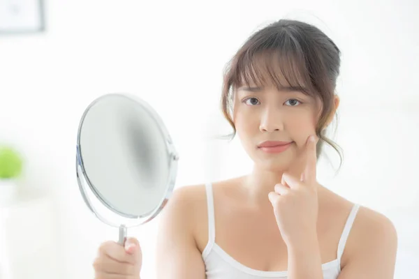 Bela jovem ásia mulher olhando o espelho com acne problema — Fotografia de Stock