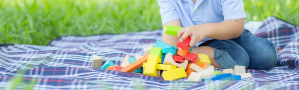 Little boy is playing for idea and inspiration with toy block in Stock Picture