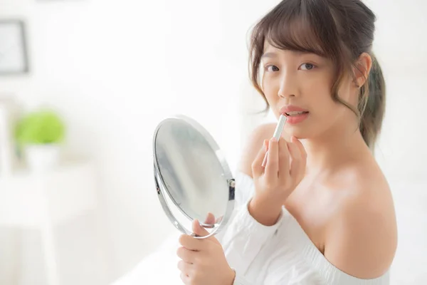Piękny portret młody Azji kobieta patrząc lustro zastosowanie mak — Zdjęcie stockowe