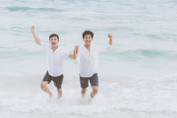 Гомосексуальный портрет молодой азиатской пары, бегущей с веселым тогом — стоковое фото