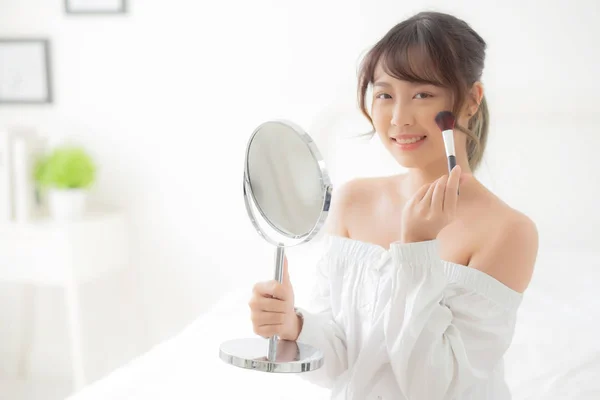 Beauty portrait young asian woman smile with face looking mirror