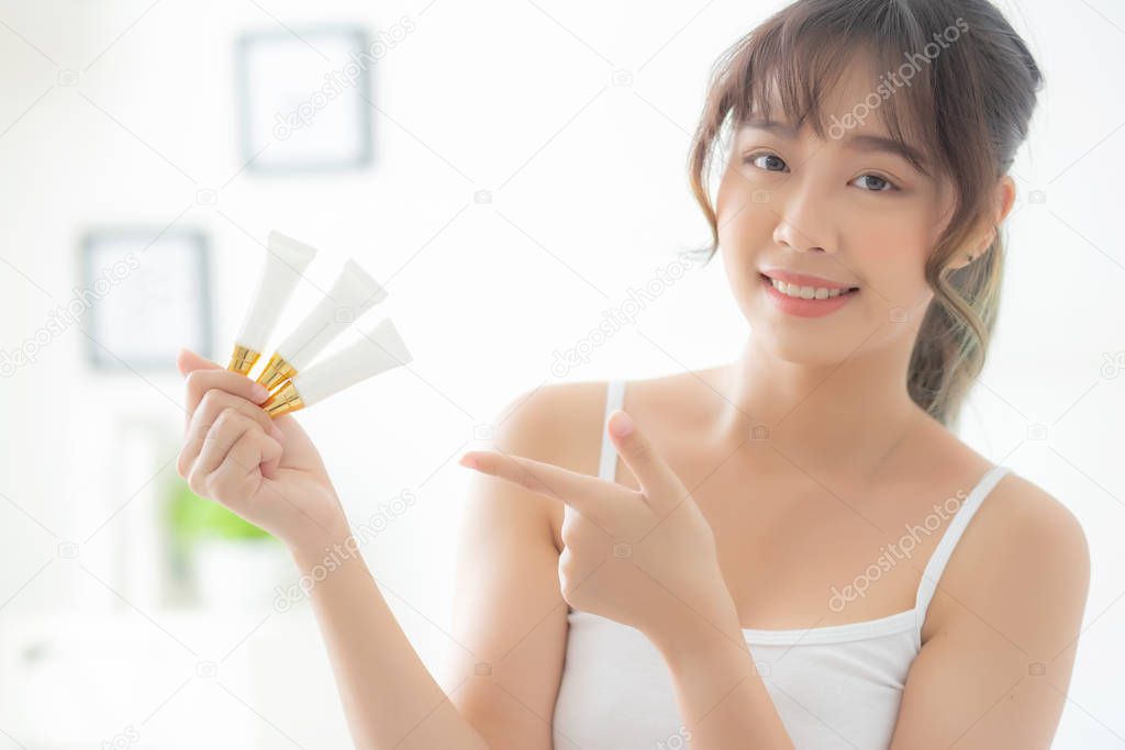 Beautiful portrait young asian woman holding and pointing presen
