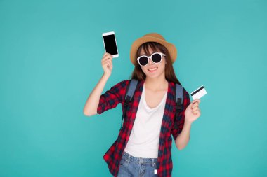 Güzel bir portre genç Asyalı kadın yaz tatili için seyahat modası kredi kartı ve akıllı cep telefonu taşıyor, Asyalı kız tatilde internetten internet rezervasyonu için ödeme yapıyor..