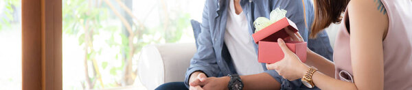 Молодая азиатская пара празднуют день рождения вместе, Азия мужчина дарения подарок женщине для сюрприза в гостиной, женщина чувствует себя счастливой и взволнованной, праздник валентинки концепции, баннер сайт
.