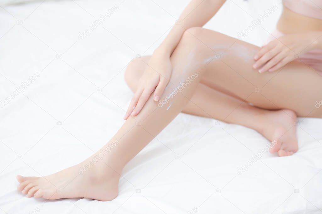 Beautiful young asian woman touch skin leg smooth with cream and lotion for hydration and smooth, girl applying body care and cosmetic for silky and soft, beauty perfect with wellness, health and care.