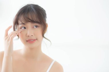 Güzel, genç Asyalı bir kadının portresi yatak odasında sağlıklı ve sağlıklı gülümsüyor, güzel Asyalı bir kızın cilt bakımı göz makyajına ve kozmetiğe taze, yaşam tarzıyla dokunuyor ve rahatlıyor..