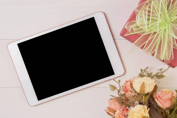 Mutlu anneler günü ya da sevgililer günü kırmızı hediye kutusu ve tablet boş ve ahşap masa üzerinde çiçek, dekorasyonla romantik hissetmek, masa başı manzaralı, tatil konsepti olan bir hediye günü..