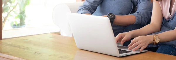 Asyalı genç çift dizüstü bilgisayarı kullanarak interneti araştırıyor ve birlikte düşünüyor, kadın ve erkek mutlu ve rahat bir şekilde gülümsüyor, iletişim ve iş konsepti, afiş web sitesi.