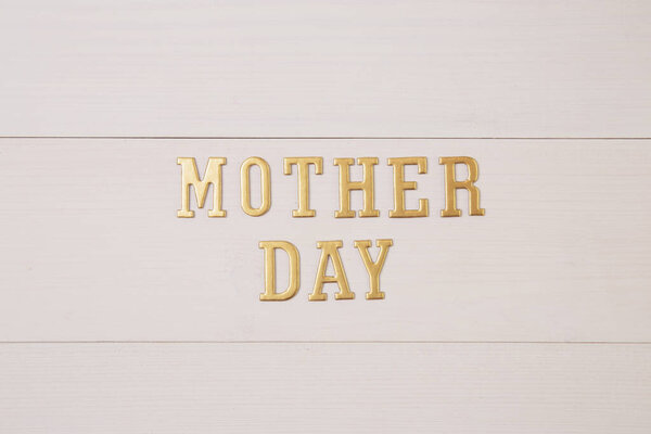 Happy mother day with gold text on wooden table, feeling romantic and care with decoration, word and alphabet mother day in festive with sign on desk, congratulation, top view, holiday concept.