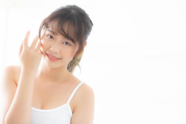 Güzel, genç Asyalı bir kadının portresi yatak odasında sağlıklı ve sağlıklı gülümsüyor, güzel Asyalı bir kızın cilt bakımı göz makyajına ve kozmetiğe taze, yaşam tarzıyla dokunuyor ve rahatlıyor..