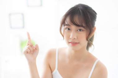 Güzel bir portre genç Asyalı kadın sağIıklı gülümsüyor ve sağIıklı, Asyalı güzel bir kız cilt bakımı ve makyaj malzemelerini sunma ve gösterme konusunda fikir sahibi, yaşam tarzı kavramı.