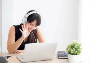 Güzel genç asyalı kadın kulaklık gülümseme giymek merhaba laptop bilgisayarda sohbet görüntülü arama kullanarak demek, kız dinlenmek müzik online dinleme keyfini çıkarın, eğitim öğrenme, iletişim ve yaşam tarzı kavramı.